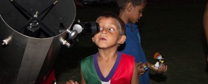 Image of a young primary school student looking into a telescope